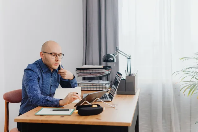 Handelsvertreter am Schreibtisch mit Tablet und Unterlagen